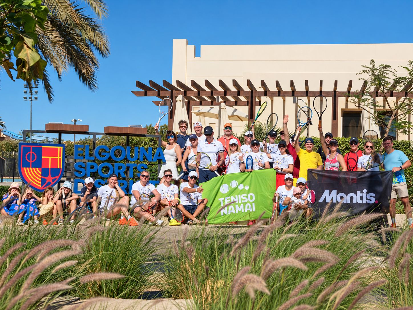 A visiting training camp group with rackets raised at El Gouna Sports District