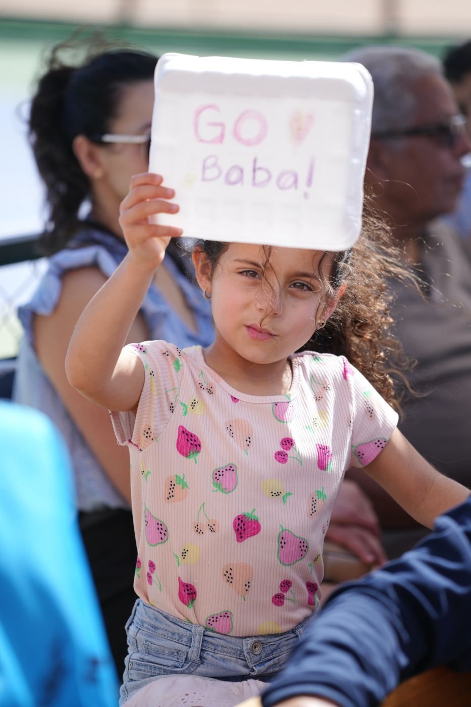 A young fan holding a Go Baba sign